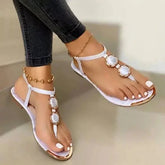 White stylish flat summer footwear with crystal embellishments and a gold ankle chain for women